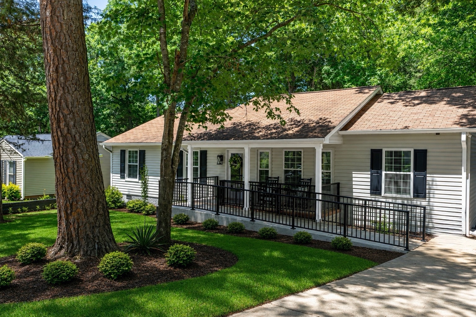 The Avendelle at Picardy Pointe home in Cary, NC — a welcoming single-story house with a wraparound porch, accessible ramp, and mature trees
